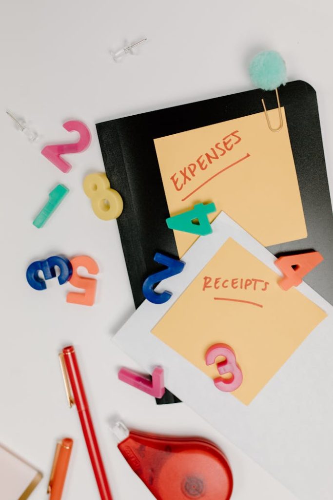 Flat lay of colorful office supplies and sticky notes labeled Expenses and Receipts.